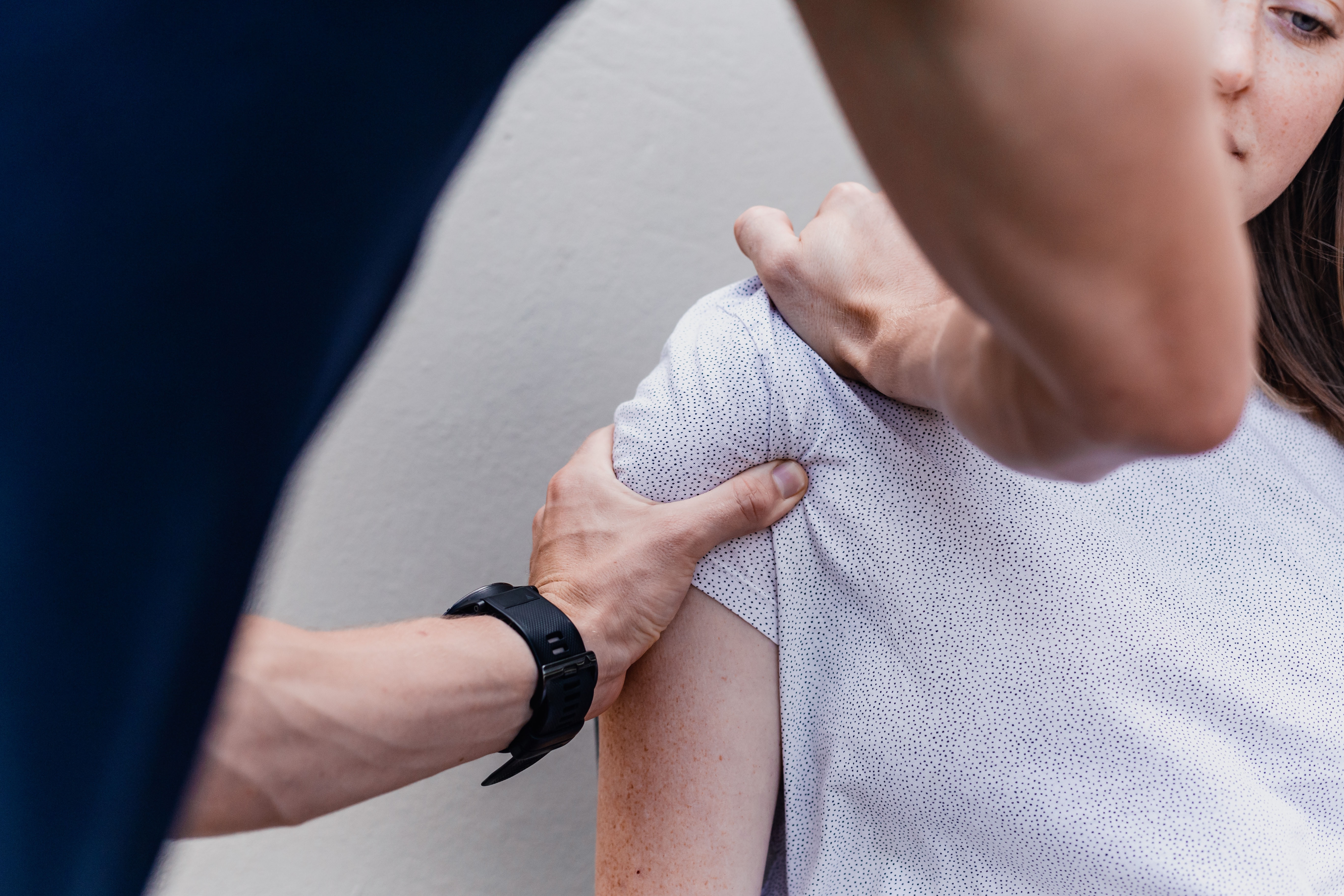 Osteopath assessing a patient's shoulder
