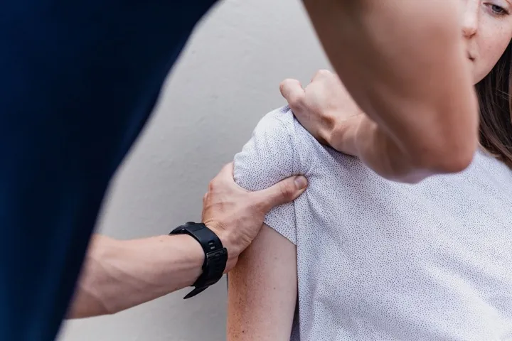 Osteopath assessing a patient's shoulder