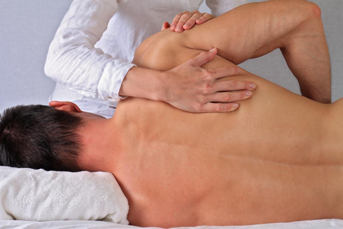 Osteopath treating a patient's shoulder and upper back